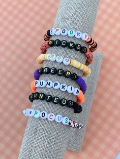 Cute Clay Bead Bracelet Ideas With Letters, Fall Theme Clay Bracelet, Color Combo Bracelets, Halloween Themed Clay Bead Bracelets, Preppy Halloween Bracelet, Aesthetic Fall Clay Bead Bracelets, Halloween Word Bracelet, Halloween Heishi Bracelet Ideas, Preppy Halloween Bracelet Ideas