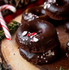 chocolate covered donuts with candy canes on a cutting board