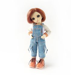 a doll with red hair wearing overalls and orange shoes, on a white background