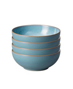 four blue bowls with gold rims stacked on top of each other in a row