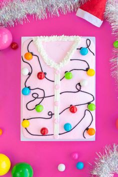 a birthday cake decorated to look like a sweater with colorful balls and candy on it