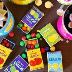 there are many candies on the table next to some cards and bowls with candy