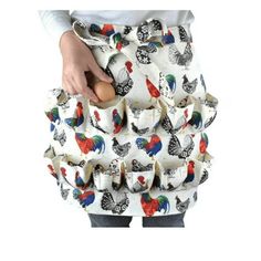 a woman is holding an egg in her hand while wearing a skirt with roosters on it