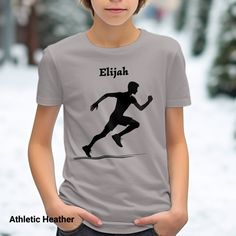 "️ Get your kid ready to race with our Youth Athletic Runner T-Shirt, featuring your custom name! Perfect for young sports enthusiasts, this comfortable tee is ideal for track and field events or casual wear. Its cool runner silhouette design will make your child stand out while they sprint towards their goals. Personalize this shirt with their name for an extra special touch and watch them wear it with pride! 🌟 This Bella Canvas 3001 is a classic unisex jersey short sleeve tee fits like a well Customizable Sporty T-shirt For Sports, Customizable Sporty T-shirt For Team Events, Customizable Sports T-shirt For Sports Season, Casual Running T-shirt With Letter Print, Sportswear T-shirt With Team Name For Training, Graphic Crew Neck T-shirt For Running, Runner Silhouette, Graphic Tee Crew Neck T-shirt For Running, Track And Field Events