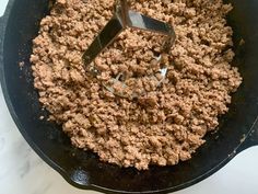 a skillet filled with ground meat on top of a white counter