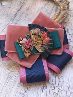 This gorgeous dusty pink,blue and green ribbon bow  brooch with hand painted deer and flowery fan in Frida Khalo style is a unique hand-made item and will allow you to add colour to your outfit.  A metal pin at the backside covered with recycled leather. Detailed, hand crafted and carefully designed. If you would like to customize(in another color,size) this or another design special to your , or if you have any other questions, please contact me, I will be happy to help! Thank you very much for Whimsical Handmade Hair Accessories For Gifts, Handmade Whimsical Hair Accessories For Gifts, Unique Pink Brooches For Party, Handmade Pink Brooches For Party, Whimsical Handmade Flower Hair Accessories For Gifts, Whimsical Handmade Flower Hair Accessories As Gift, Handmade Multicolor Hair Accessories For Gift, Handmade Pink Party Brooches, Whimsical Multicolor Hair Accessories For Gift