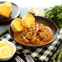 a bowl filled with shrimp and bread on top of a table