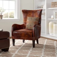 a brown leather chair sitting on top of a rug