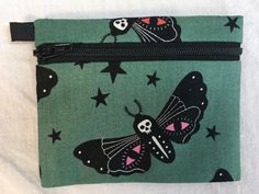 "These moths are black and white with varying color accents and are on a medium green background. Notice the eyes on their wings and their skull faces. I now have this design available in three colors (photo 10) gray, pale lavender and deep teal. Please choose your favorite at checkout. The purse is made of and lined with 100% cotton fabric. It has a layer of light interfacing for stability and all raw edges are serged for. durability. Design placement may vary. The purse has a side loop so you Blue Coin Purse With Card Slots, Green Coin Purse With Zipper, Compact Blue Coin Purse, Blue Coin Purse With Zipper Closure, Compact Coin Purse With Removable Pouch For On-the-go, Folding Money, Moon Moth, Air Pods, Skull Face