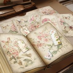 an open book sitting on top of a table filled with lots of flowers and butterflies