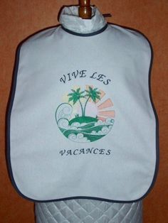 This adult bib allows the person being handled or behaved to have a meal or drink with dignity and without getting dirty. This personalized adult bib with text made from white cotton fabric covers the upper body to protect clothes from possible food stains. Bib finishes: - gray cotton bias. Embroidered text: -Long live the holidays. Embroidered pattern: -Beach palm in medallion. Two ties at the neckline to attach it. Dimensions: L 63 cm x W 43 cm. Ties: 35 cm. Special embroidery cotton threads used in colors, gray, green, yellow, orange. Unique piece Gift idea for retirement, original gift etc.... White Cotton Washable Bib, White Washable Cotton Bib, Adult Bibs, Food Stains, White Cotton Fabric, Embroidery Cotton, Protective Clothing, Linen Napkins, Original Gift