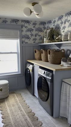 a washer and dryer sitting in a room next to a counter with baskets on it