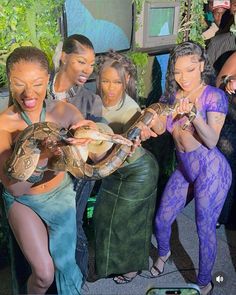 the girls are all dressed up and holding snakes