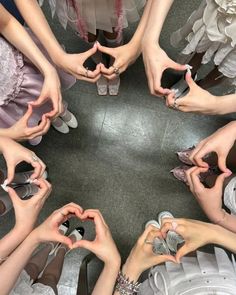 a group of people holding their hands in the shape of a heart