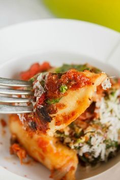 a white plate topped with lasagna covered in sauce and cheese