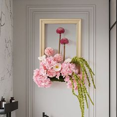 pink flowers are hanging on the wall above a mirror