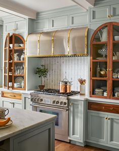 a kitchen with an oven, stove and cupboards in the middle of it's counter space