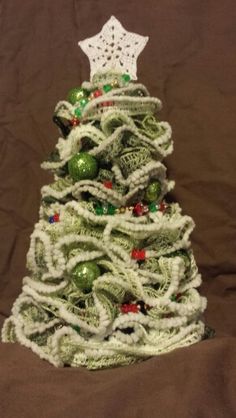 a small christmas tree made out of yarn