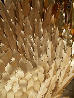 an intricately designed piece of art made out of wood and metal, with leaves on it