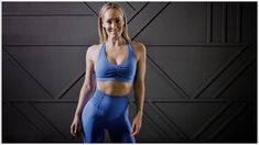 a woman in blue sports bra top and leggings posing for a photo with black background