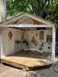 a small white house sitting on top of a wooden deck