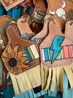 leather key fobs with colorful designs and fringes on them are laying next to each other