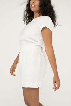 An artfully engineered top built for versatility and adaptability. This blouse can be worn with the knot in the front or the back, and also works wonderfully layered over tanks and dresses. Try tying it loosely for a relaxed fit, or tightly for a waist-cinching, pin-up silhouette. It boasts a low v-neck front- or full coverage in front with a low v-open back. Try tying the knot around the center front or back of your bra to help disguise it and keep the top securely in place. Simple rolled hems Casual Summer Blouse With Tie Waist, Summer Drawstring Tops For Loungewear, Summer Tie Waist Blouse For Day Out, Chic Beach Tops With Drawstring Tie, Short Sleeve Drawstring Top For Beach, Drawstring Short Sleeve Tops For Beach, Chic Summer Tops With Tie Fastening, Chic Summer Top With Tie Fastening, Chic Wrap Top With Tie Back