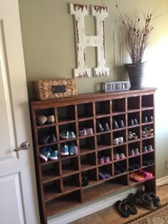 a wooden shoe rack filled with shoes next to a door