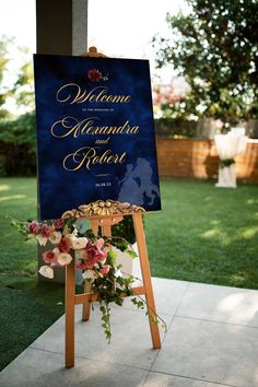 a sign with flowers on it sitting in the grass