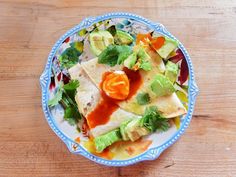 a plate with quesadillas and guacamole on it sitting on a wooden table