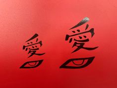 two chinese characters are drawn on a red surface