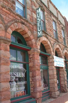 an old brick building with many windows and signs on the side of it that read museum