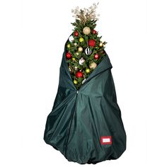 a christmas tree is wrapped up in a green bag with ornaments on it and an ornament hanging from the top