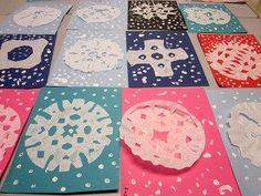 paper doily laid out on the floor to be made into snowflakes