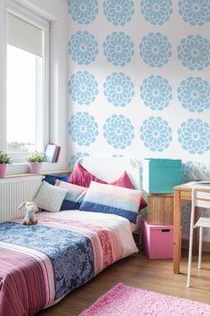 a bedroom with pink and blue decor on the walls