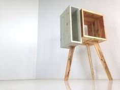 a small wooden object sitting on top of a white floor in front of a wall