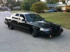 a black police car parked in front of a house