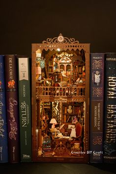 several books are stacked on top of each other in front of a miniature doll house