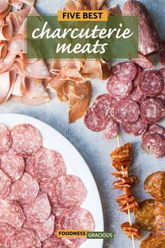 several different types of meats on a white plate next to some other food items