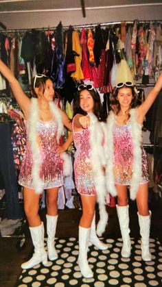 three girls dressed up in costumes posing for the camera