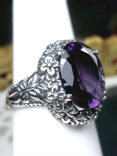 Simulated or Natural Purple Amethyst Ring Butterfly Design#79 Custom Made Introducing our stunning Amethyst Ring, inspired by the elegant Art Nouveau style of the early 20th century. This solid sterling silver ring features a flawless 5ct oval simulated or natural purple amethyst gemstone, with the option to choose your preferred stone. Measuring 14mm in length and 10mm in width, this ring sits 8mm off the finger for a comfortable fit. The band is marked 925 for authenticity. The intricate silver filigree setting and band are adorned with delicate floral and butterfly designs, a nod to the Art Nouveau movement. This unique and eye-catching ring is a must-have for any jewelry lover. It comes beautifully presented in a gift box, perfect for safekeeping and gift-giving. If you have any questi Ring Butterfly, Floral Filigree, Purple Amethyst Ring, Purple Jewelry, Purple Band, Elegant Art, Silver Butterfly, Silver Filigree, Butterfly Design