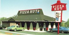 a pizza hut with cars parked in front