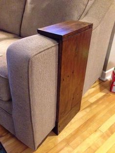 a couch with a wooden table on top of it next to a gray sofa and red canister