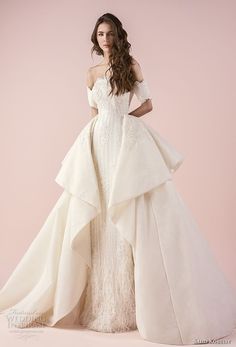 a woman in a white wedding dress standing on a pink background with her hands on her hips