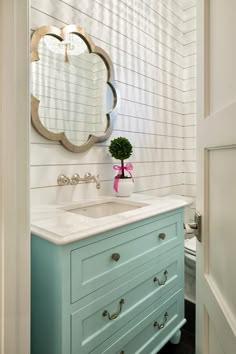 a bathroom with white walls and blue drawers