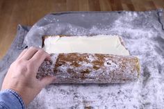 a person is spreading icing on a loaf of bread