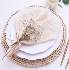 the table is set with plates, napkins and flowers on top of each plate