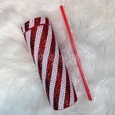 a red and white striped case next to a straw