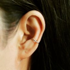 a close up of a person's ear with a small ring on the end