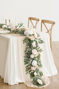 the table is decorated with white flowers and greenery